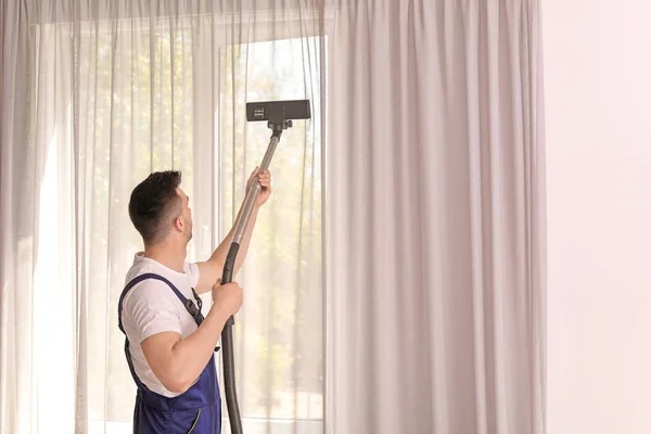 depositphotos_196808458-stock-photo-male-worker-removing-dust-curtains